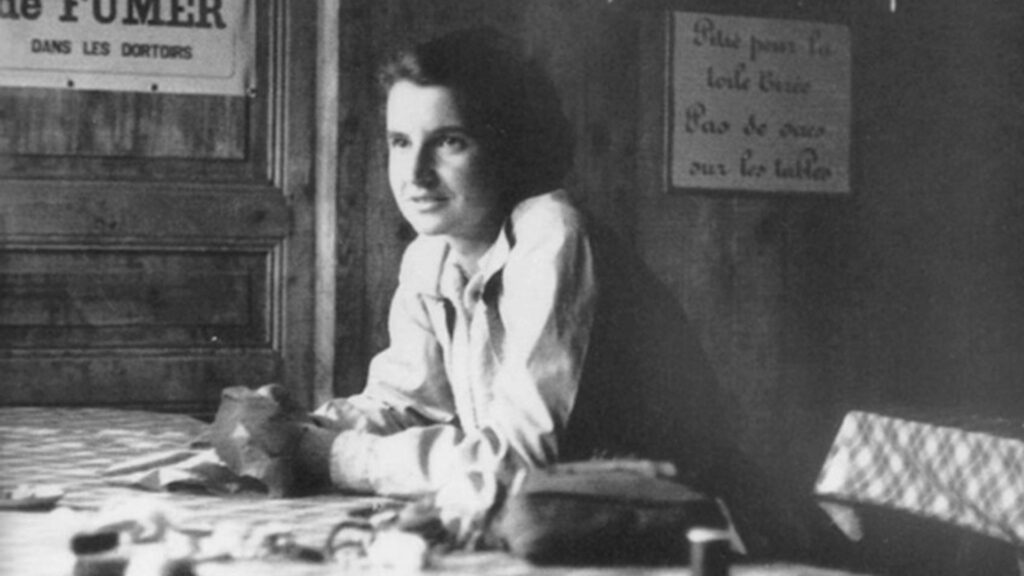 Rosalind Franklin sentada en una cafetería durante su estancia en París, en una fotografía en blanco y negro de la década de 1950.